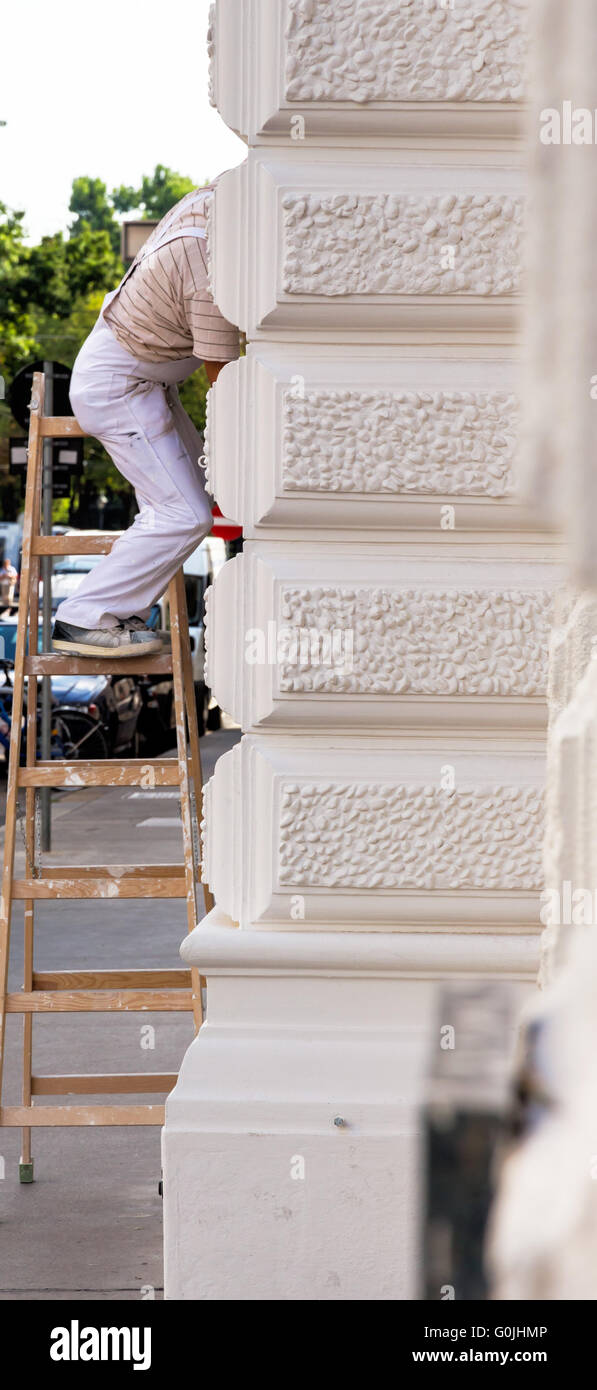 Maler auf einer Leiter am Arbeitsplatz Stockfoto