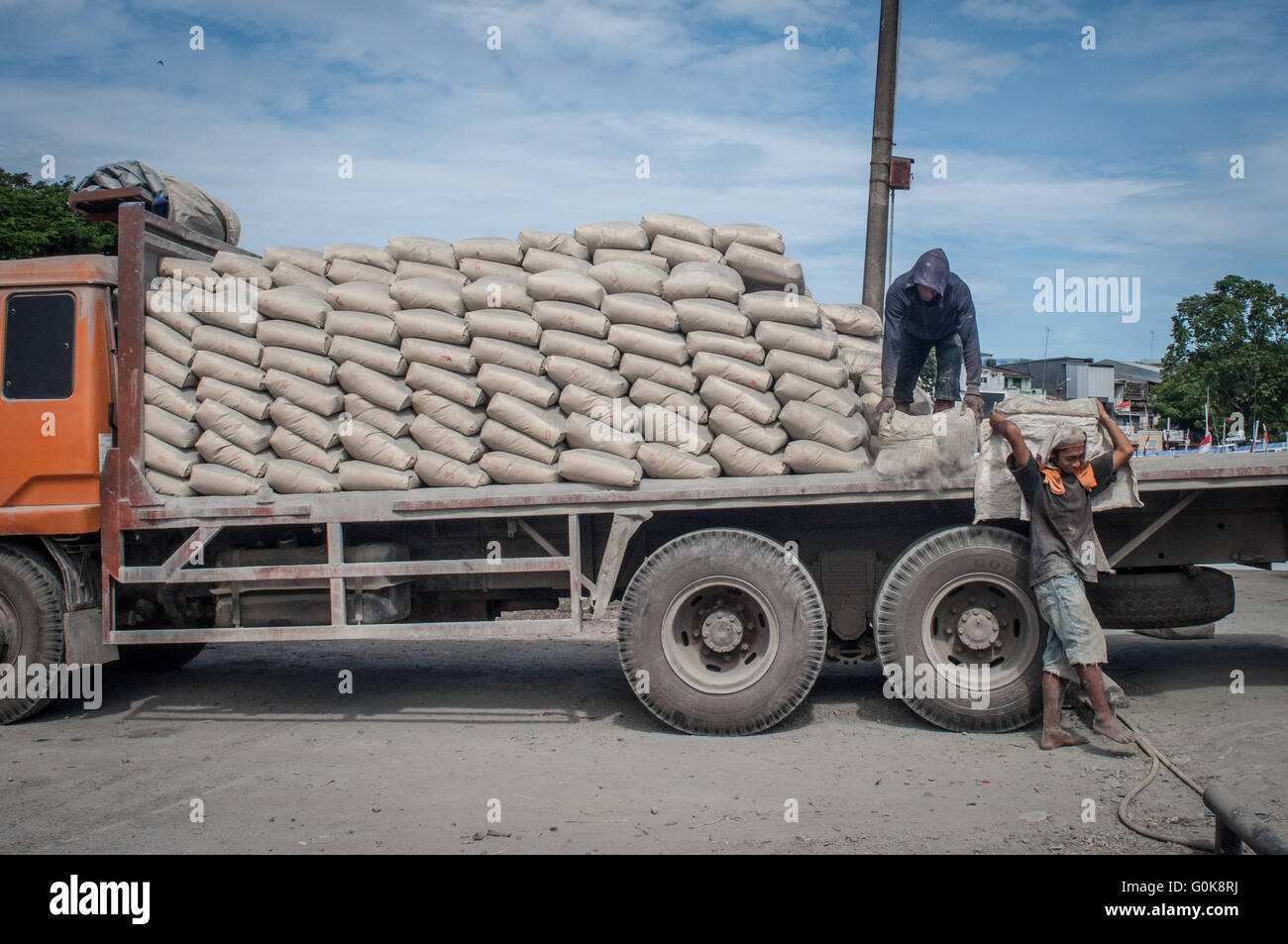 Männer bewegen eine Plünderung Zement am Paotere Hafen in Makassar, Indonesien. Stockfoto