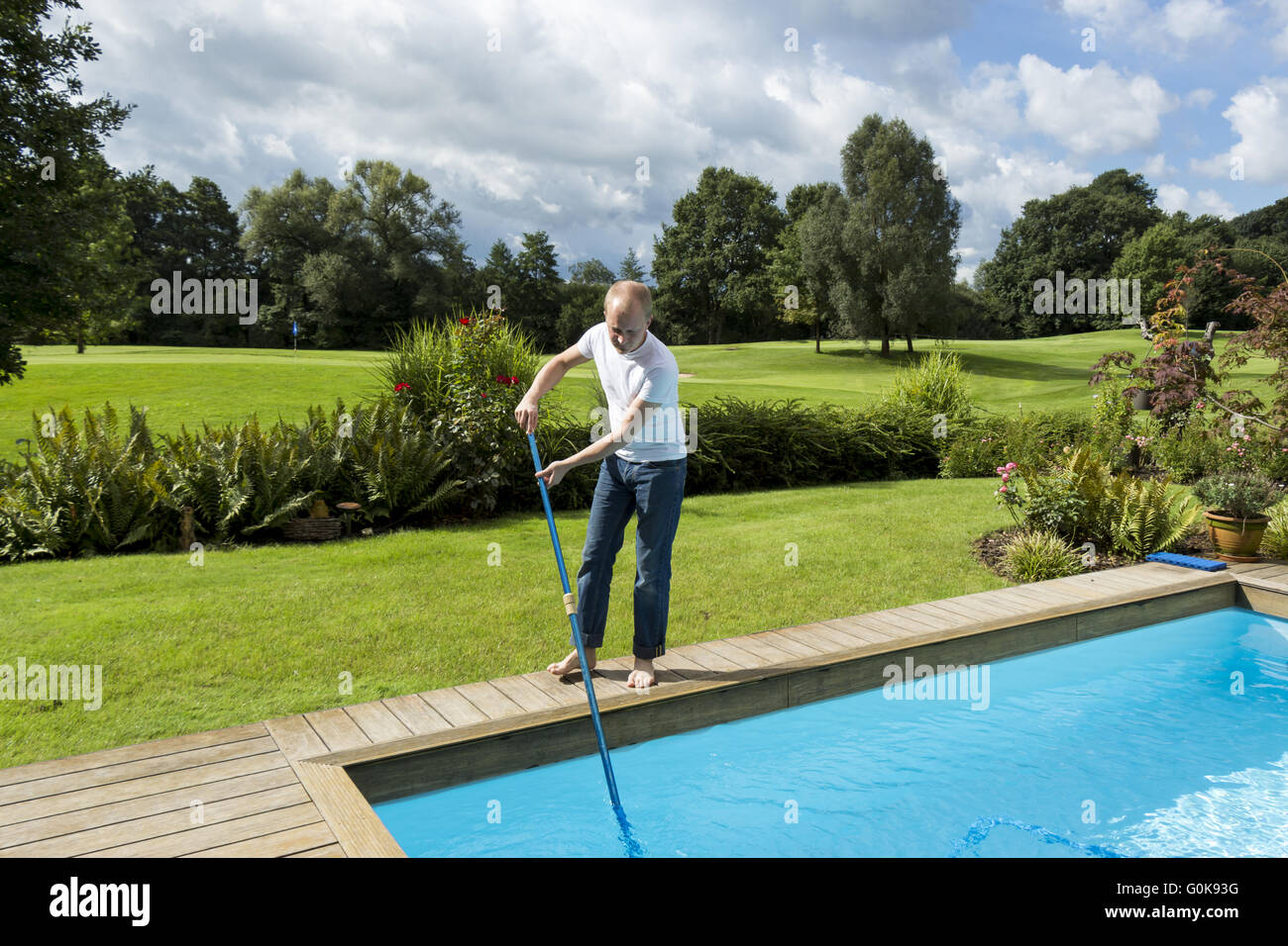 Mann Reinigung Schwimmbad Stockfoto
