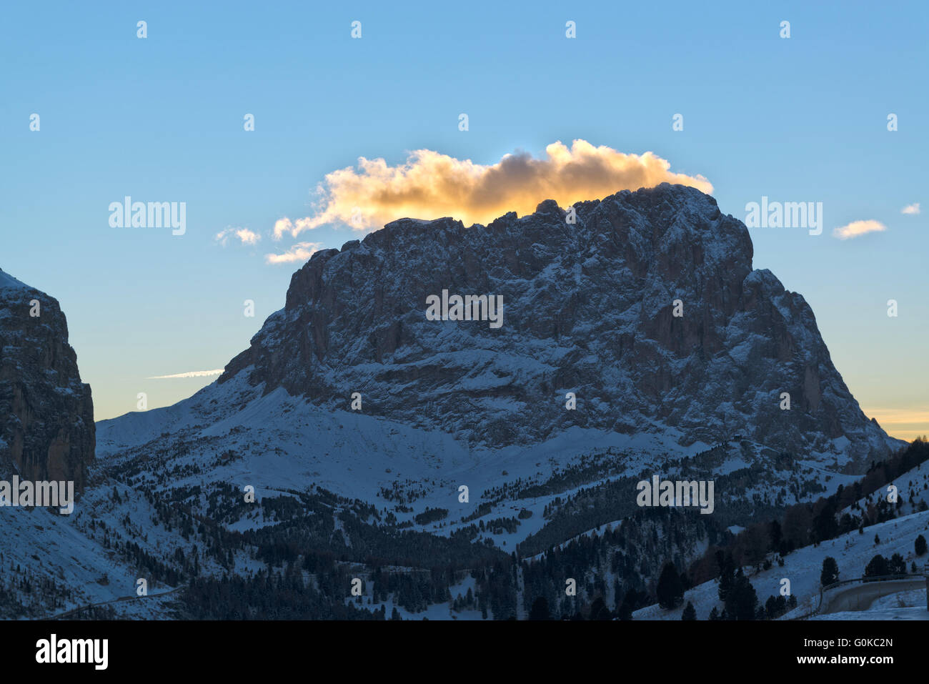 sonnendurchflutete Wolken bei Sonnenuntergang über den Berg Langkofel im Winter, Dolomiti Stockfoto