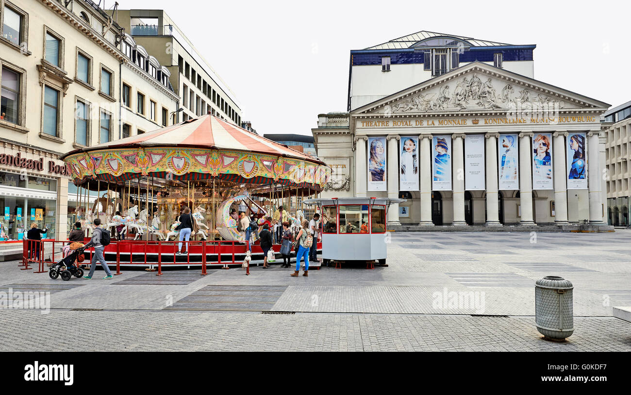 Einige Leute genießen einen schönen Tag im September um ein Karussell installiert vor dem Königlichen Theater la Monnaie in Brüssel. Stockfoto