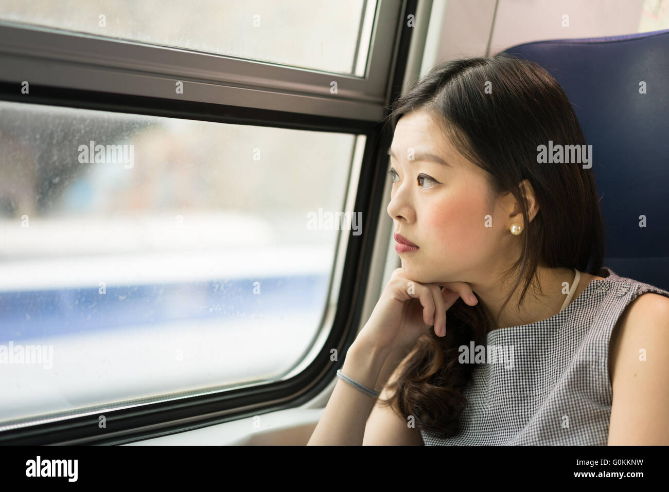 Schöne asiatische Frau Blick aus dem Zugfenster mit Textfreiraum Stockfoto
