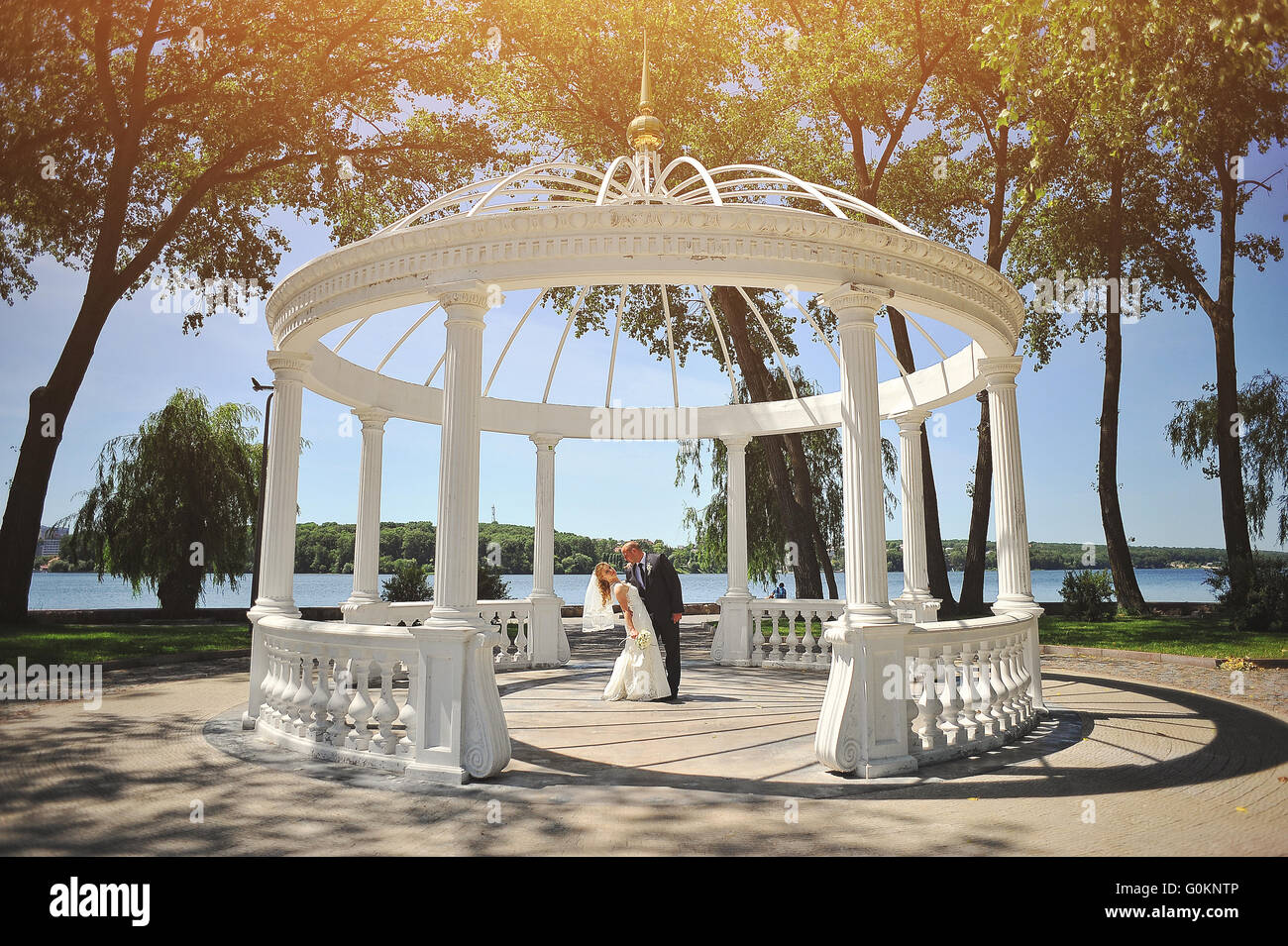 Nur verheiratete Paar zu Fuß in Liebe unter Bogen der Liebenden Stockfoto