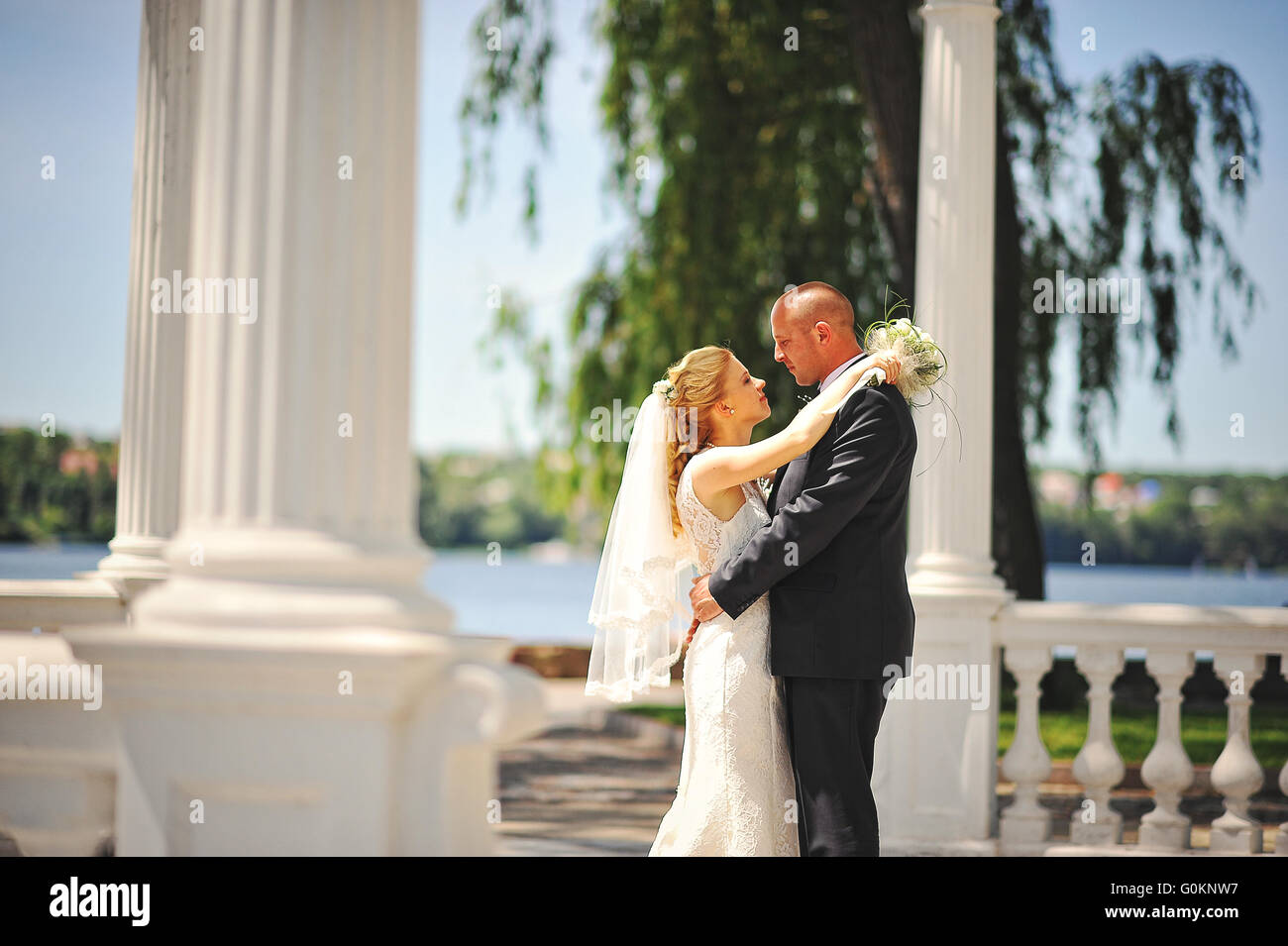 Nur verheiratete Paar zu Fuß in Liebe unter Bogen der Liebenden Stockfoto