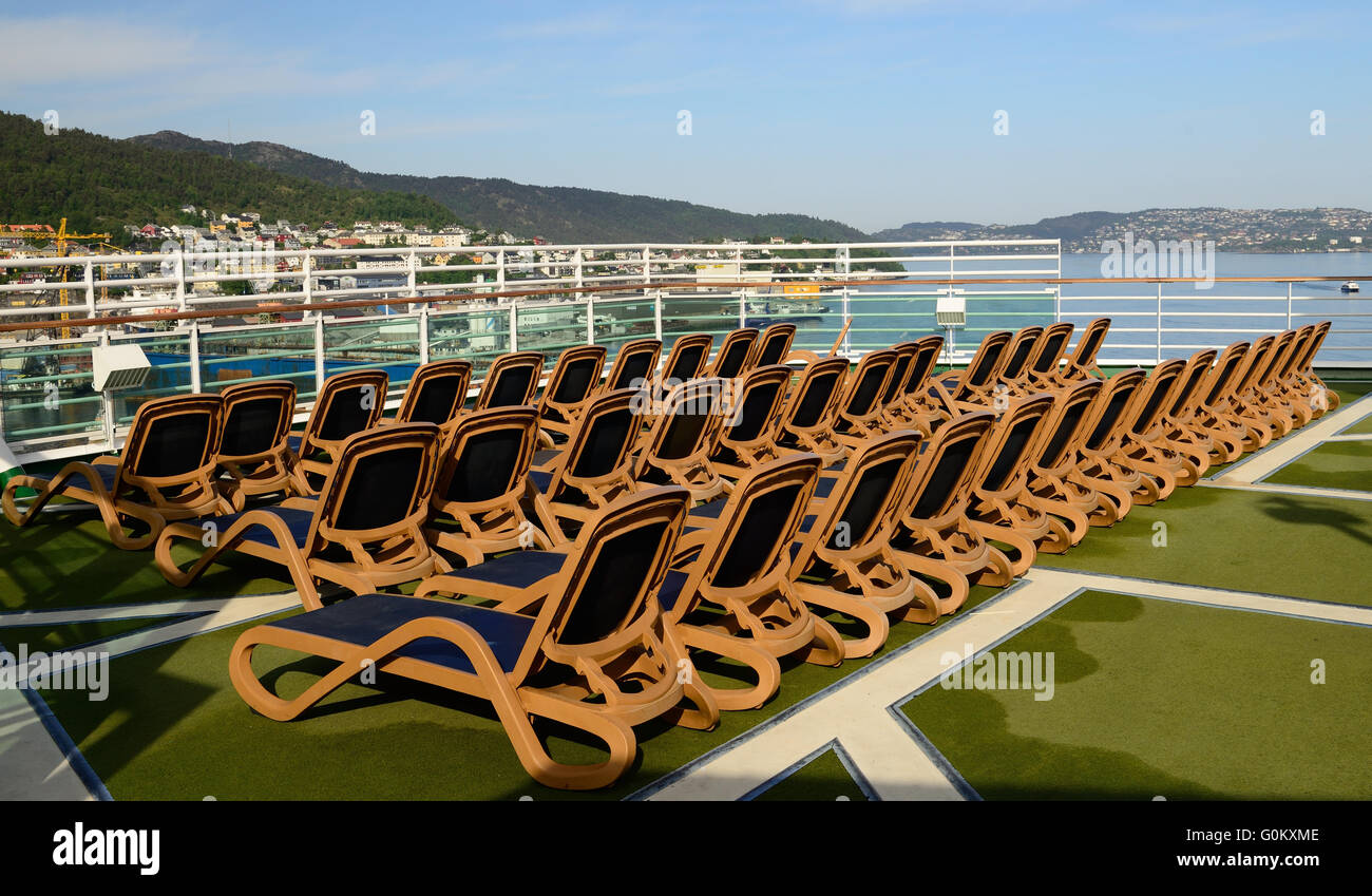 Leere Liegestühle auf dem oberen Deck eines Kreuzfahrtschiffes. Stockfoto