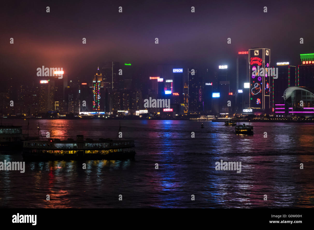 Panorama der Innenstadt von Hongkong in einer nebligen Nacht. Star Fähren Kreuzung Victoria Harbour. Stockfoto