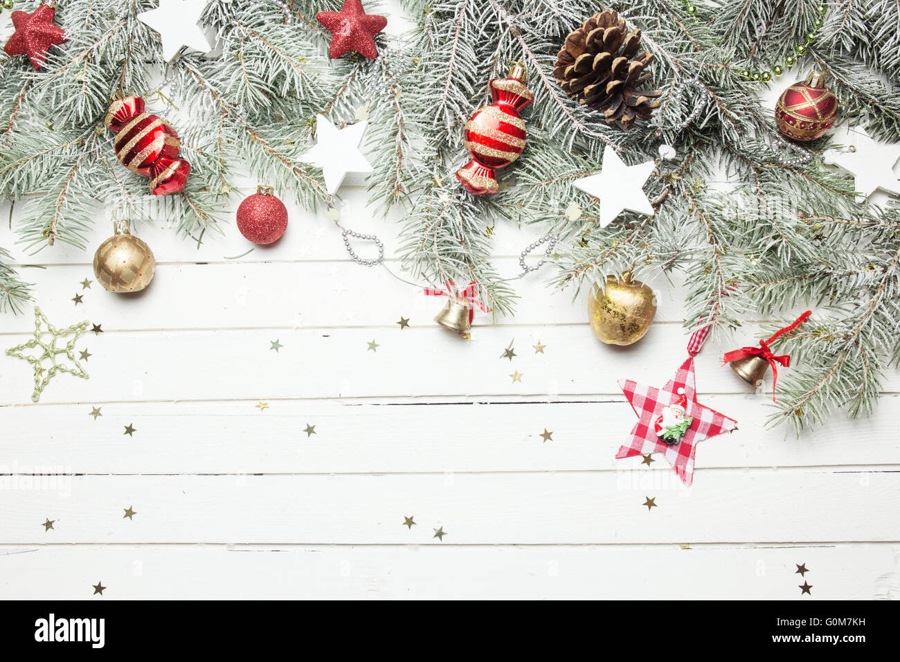 Weihnachten oder Neujahr Hintergrund: Tanne Äste, bunte Glaskugeln, Dekoration und glitzernden Sternen auf weißem Holz, Ansicht von oben kopieren Raum. Stockfoto