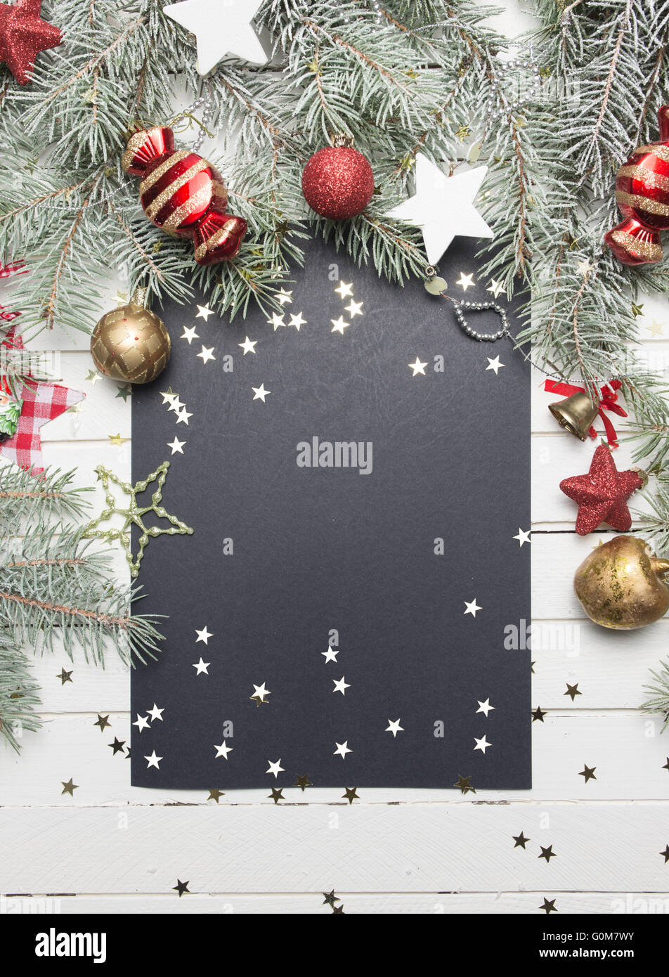 Weihnachten oder Neujahr Hintergrund: Tanne Äste, bunte Glaskugeln, Dekoration und glitzernden Sternen auf weißem Holz, Ansicht von oben kopieren Raum. Stockfoto