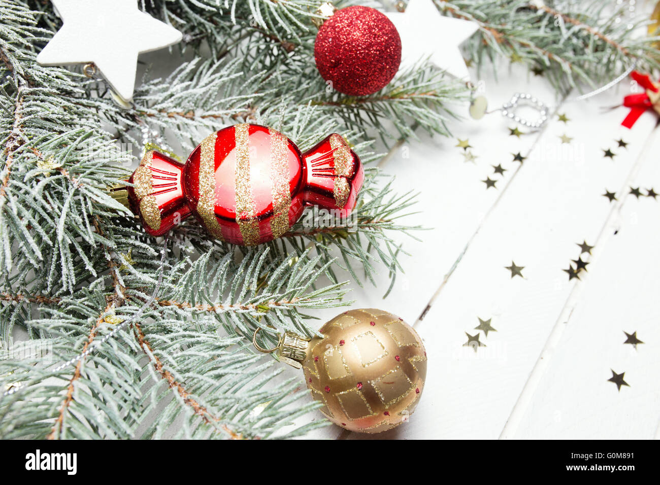 Weihnachten oder Neujahr Hintergrund: Tanne Äste, bunte Glaskugeln, Dekoration und glitzernden Sternen auf weißem Holz, Ansicht von oben kopieren Raum. Stockfoto