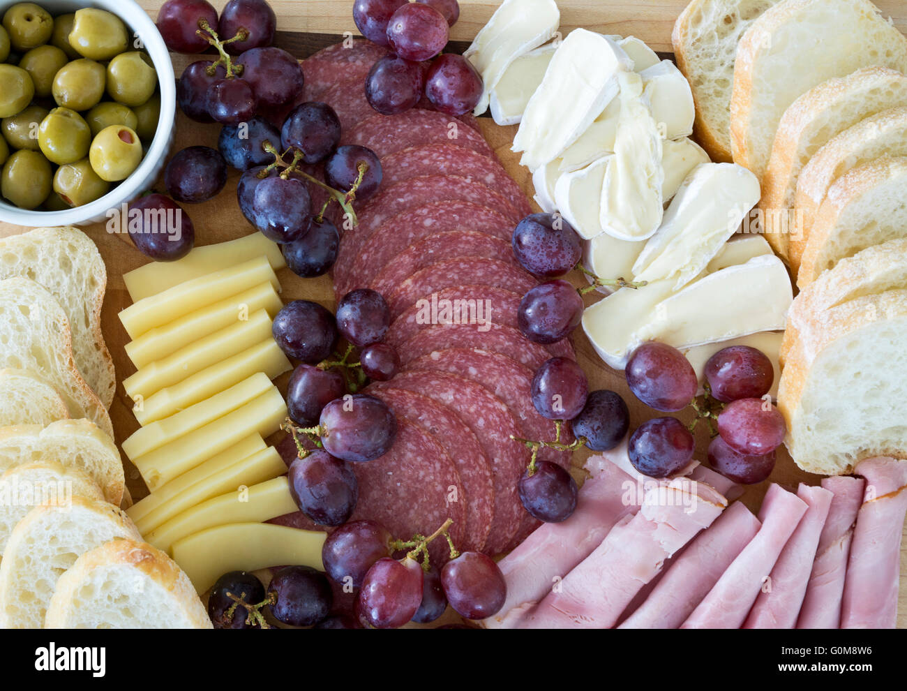 Charcuterie mit Aufschnitt, Käse, Brot und Oliven. Fleisch- und Käseweidebrett mit Trauben und Oliven. Stockfoto