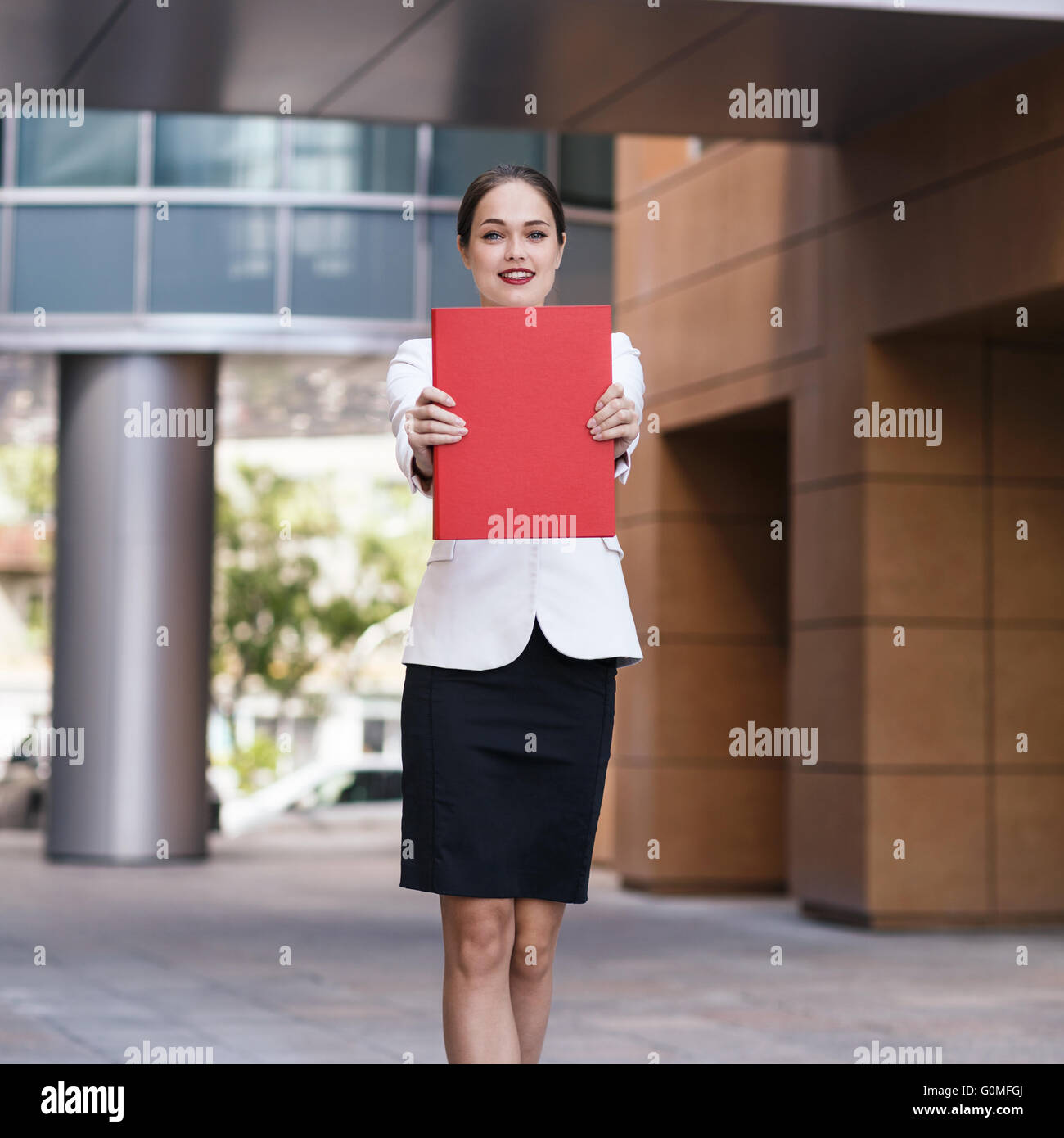 Glückliche junge Geschäftsfrau mit einem Ordner Stockfoto