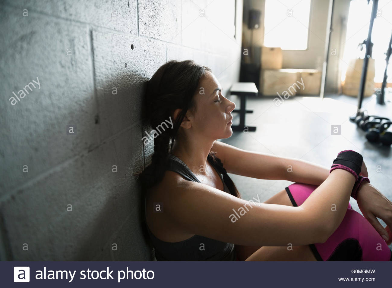 Müde Frau ruht in Turnhalle Stockfoto