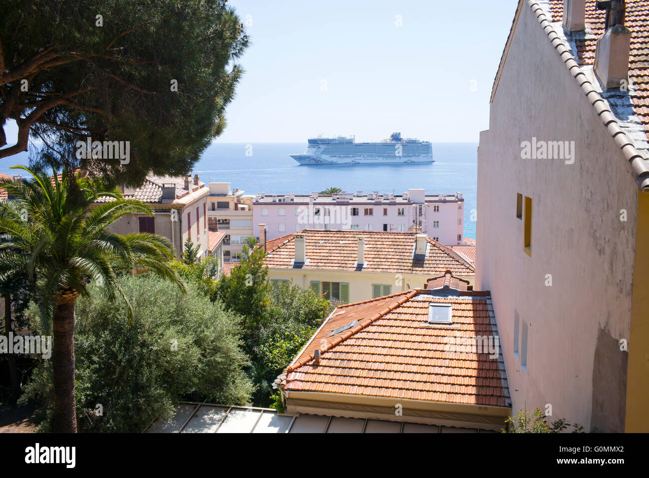 Ein Kreuzfahrtschiff in Cannes, Frankreich, gesehen durch Gebäude in der Altstadt Le Suquet festgemacht. Stockfoto