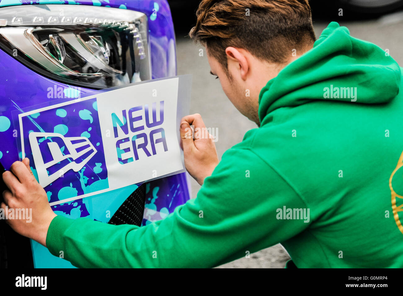 DUBLIN, IRLAND. 1. Mai 2016 - gilt ein Mann Vinyl Sticker für ein Auto zu Beginn des Rennens Gumball 3000 nach Budapest. Stockfoto