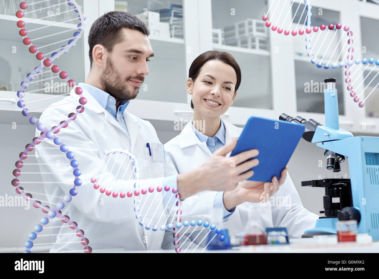 Wissenschaftler mit TabletPC und Mikroskop im Labor Stockfoto