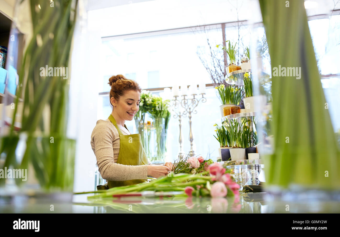 lächelnde Florist Frau machen Menge im Blumenladen Stockfoto