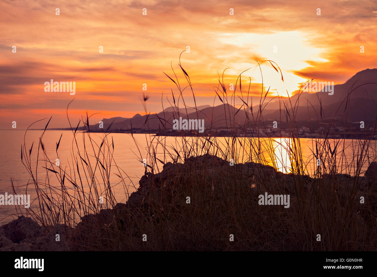 Bild der farbenfrohen Sonnenuntergang Landschaft auf Kreta, Griechenland. Das Dorf Mkrigialos im Hintergrund. Stockfoto