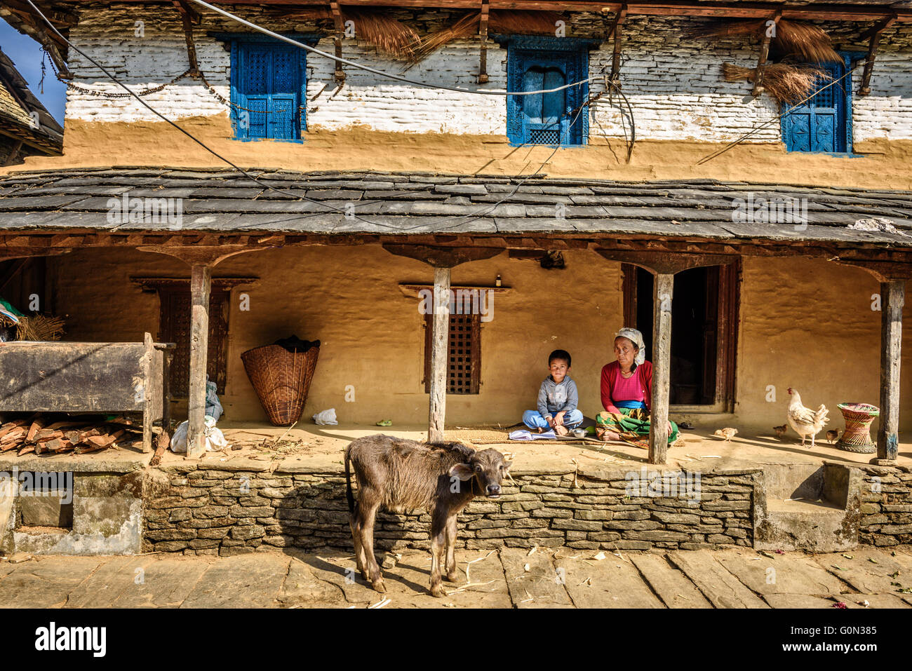 Nepalesische Bauer Frau mit ihrem Sohn im Hinterhof ihres Hauses Bauernhof Stockfoto