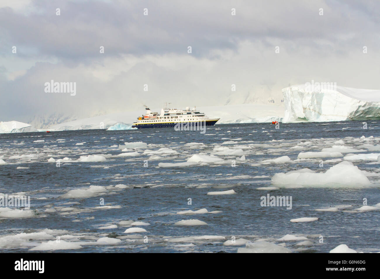 Kreuzfahrt Schiff durch schwimmende Eisfeld in der Antarktis mit dramatischen Himmel. Stockfoto
