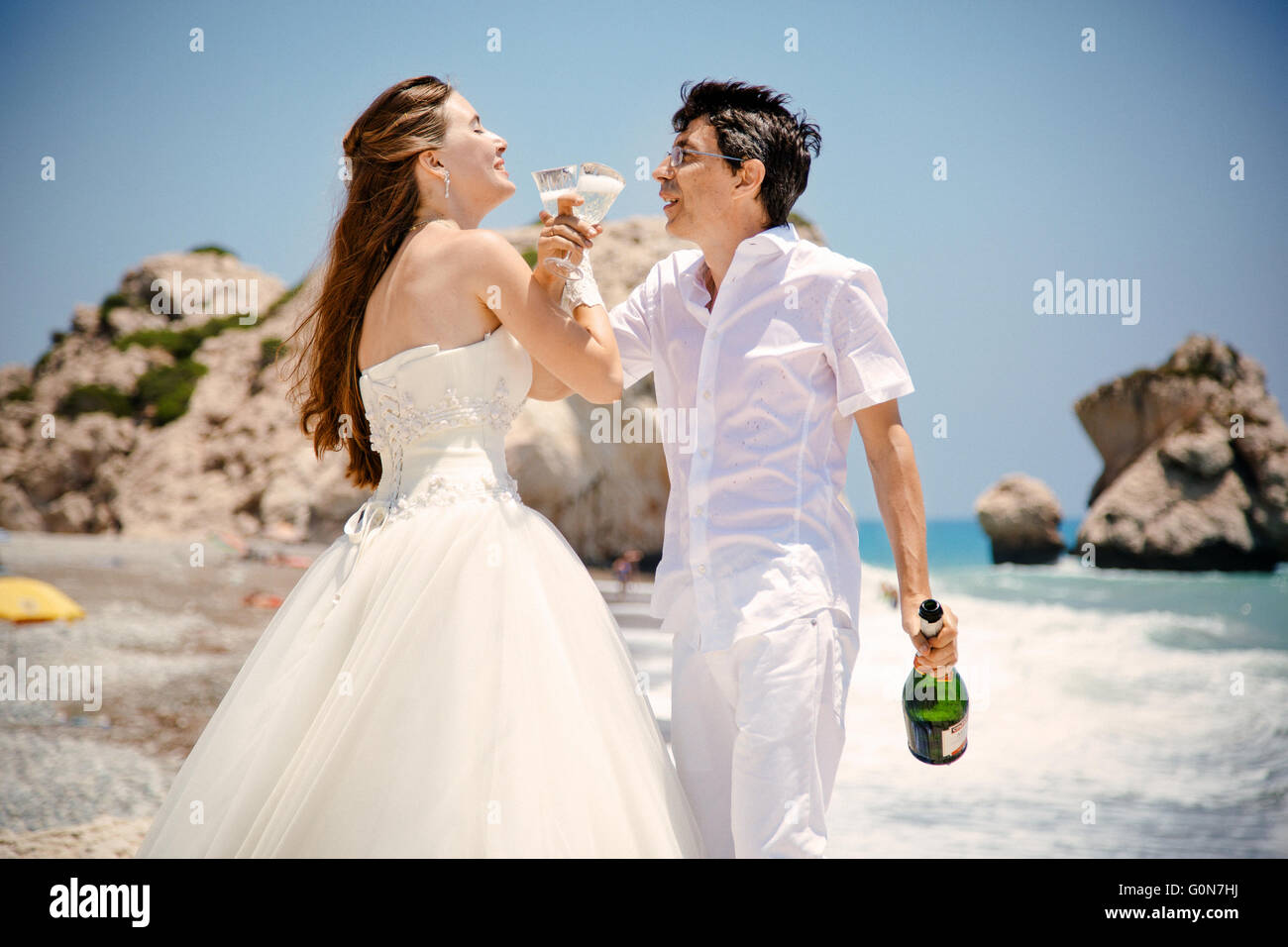 Braut und Bräutigam mit Gläsern Champagner am Strand Mittelmeer Stockfoto