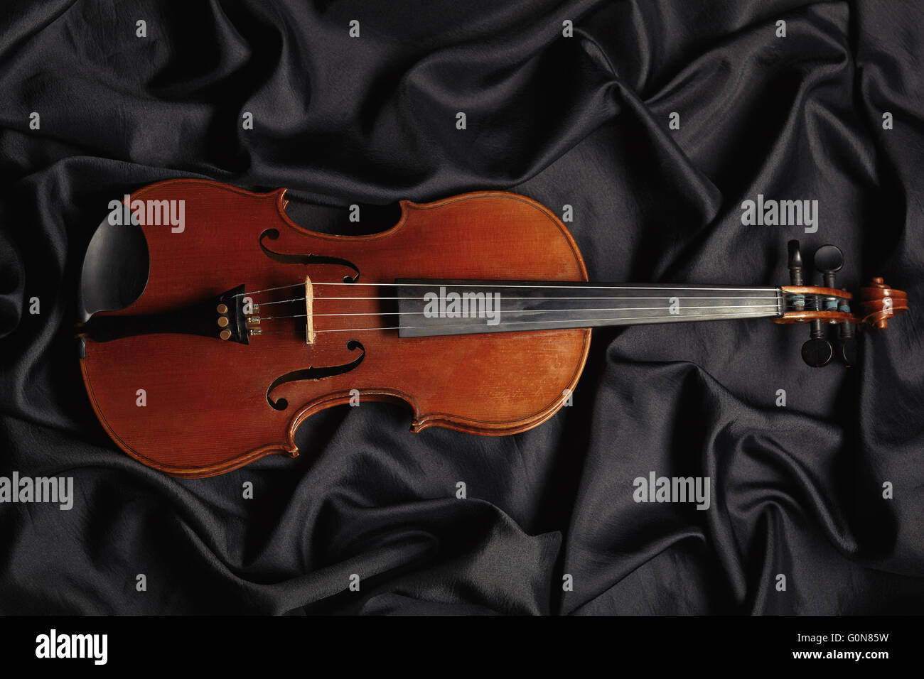 Alte Geige auf dunkle Textur Stockfoto