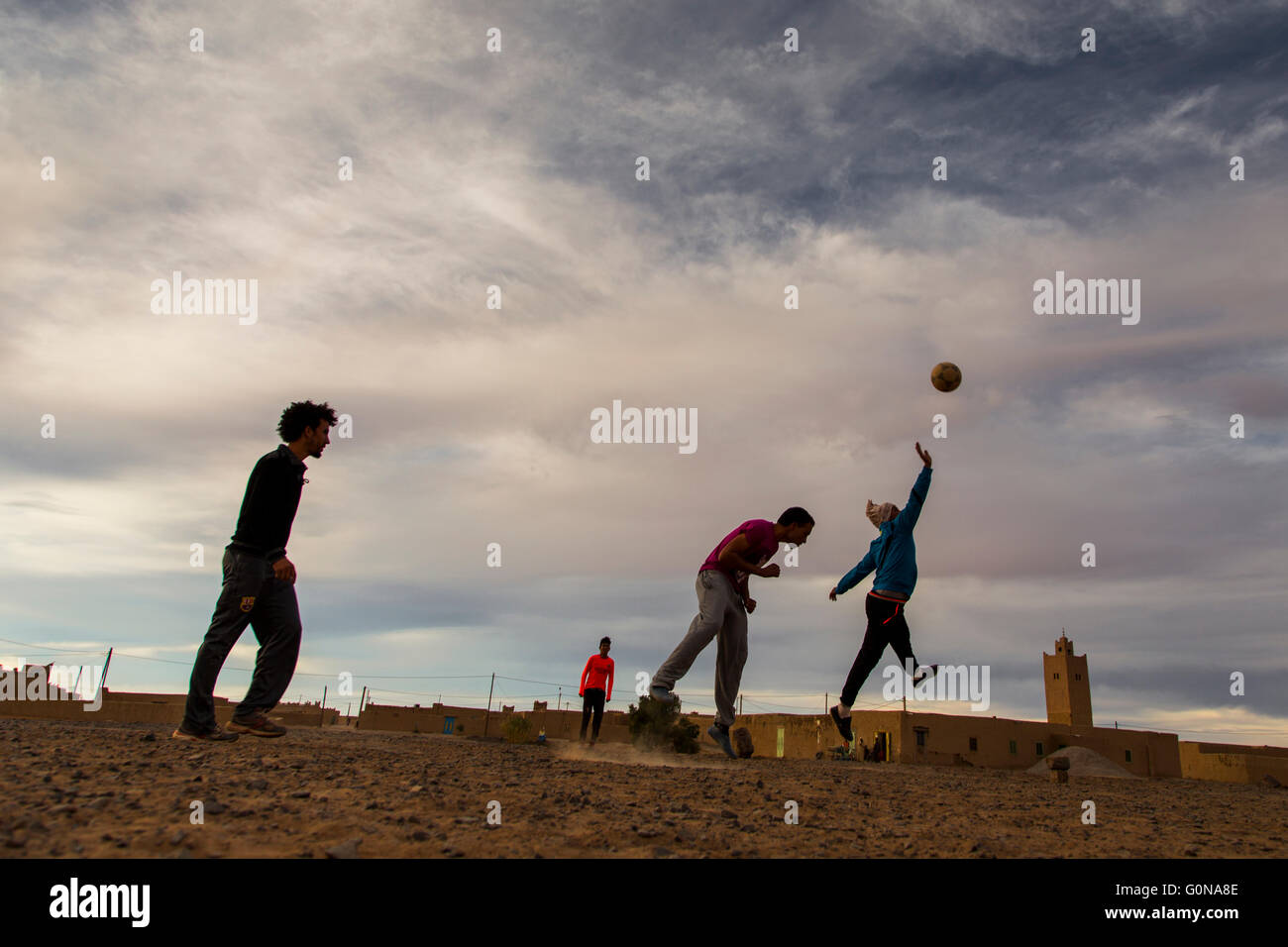 Männer Fußball spielen auf den Straßen von Merzouga Stockfoto