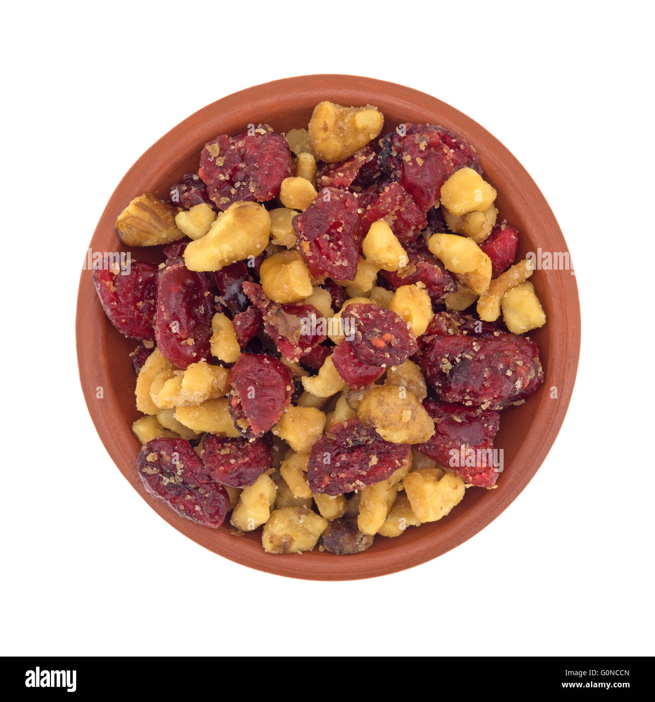 Draufsicht auf eine kleine Schüssel gefüllt mit Cranberries und Walnüssen isoliert auf einem weißen Hintergrund. Stockfoto