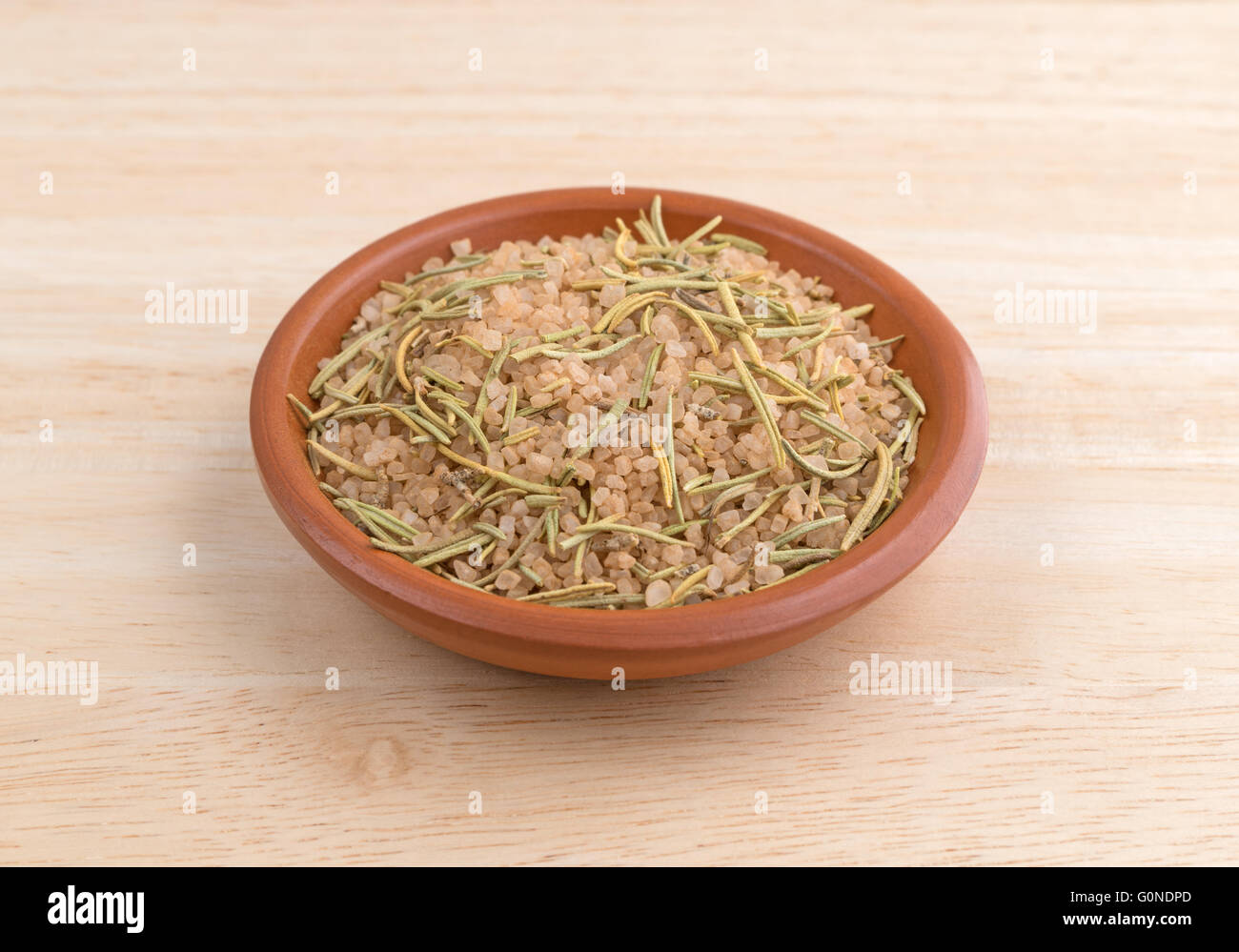 Eine einfache Mischung aus toskanischen Würze in einer kleinen Schüssel auf einer hölzernen Tischplatte Teil. Stockfoto