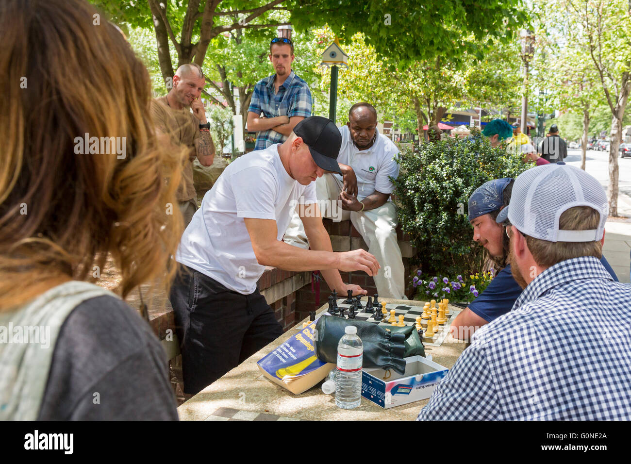 Asheville, North Carolina - Schauspieler Woody Harrelson (schwarze Kappe) spielt Schach in Pritchard Park. Viele Stammgäste Park sind obdachlos. Stockfoto