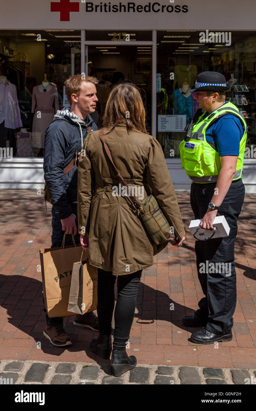 Zwei Personen im Gespräch mit einem PCSO, High Street, Lewes, UK Stockfoto