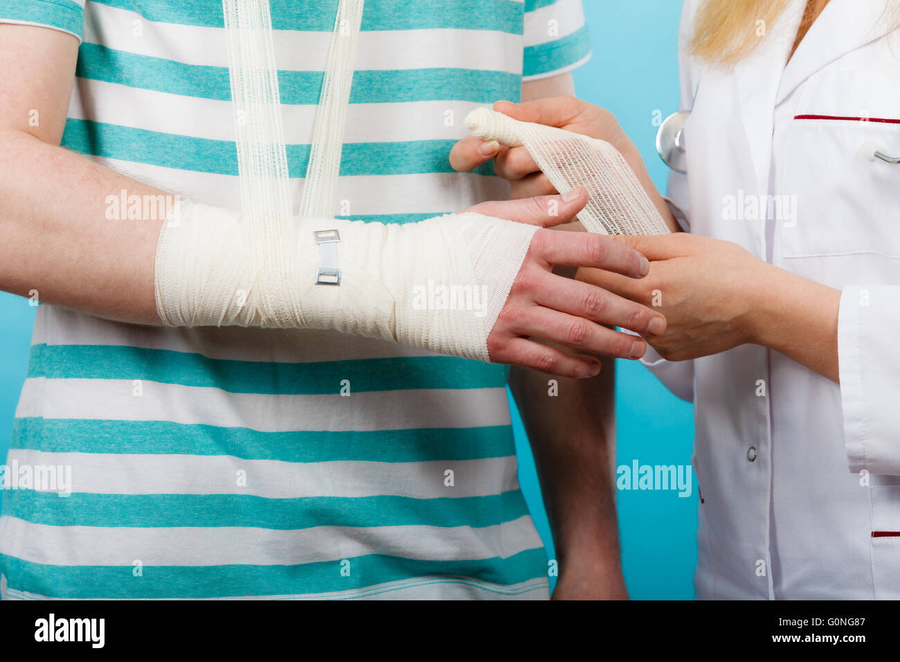 Gesundheit und Schutz. Junger Mann mit gebrochenen Handgelenk verstaucht weiblichen Arzt aufsuchen. Spezialist mit Bandage. Stockfoto Gesundheit und Schutz. Junger Mann mit gebrochenen Handgelenk verstaucht weiblichen Arzt aufsuchen. Spezialist mit Bandage. Stockfoto