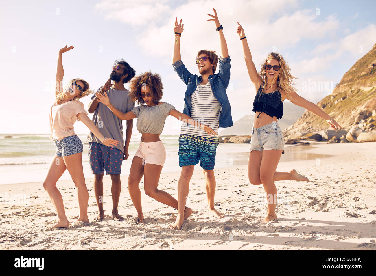 Porträt von begeistert junge Freunde am Strand stehen. Gemischtrassigen Gruppe von Freunden, die einen Tag am Strand zu genießen. Stockfoto