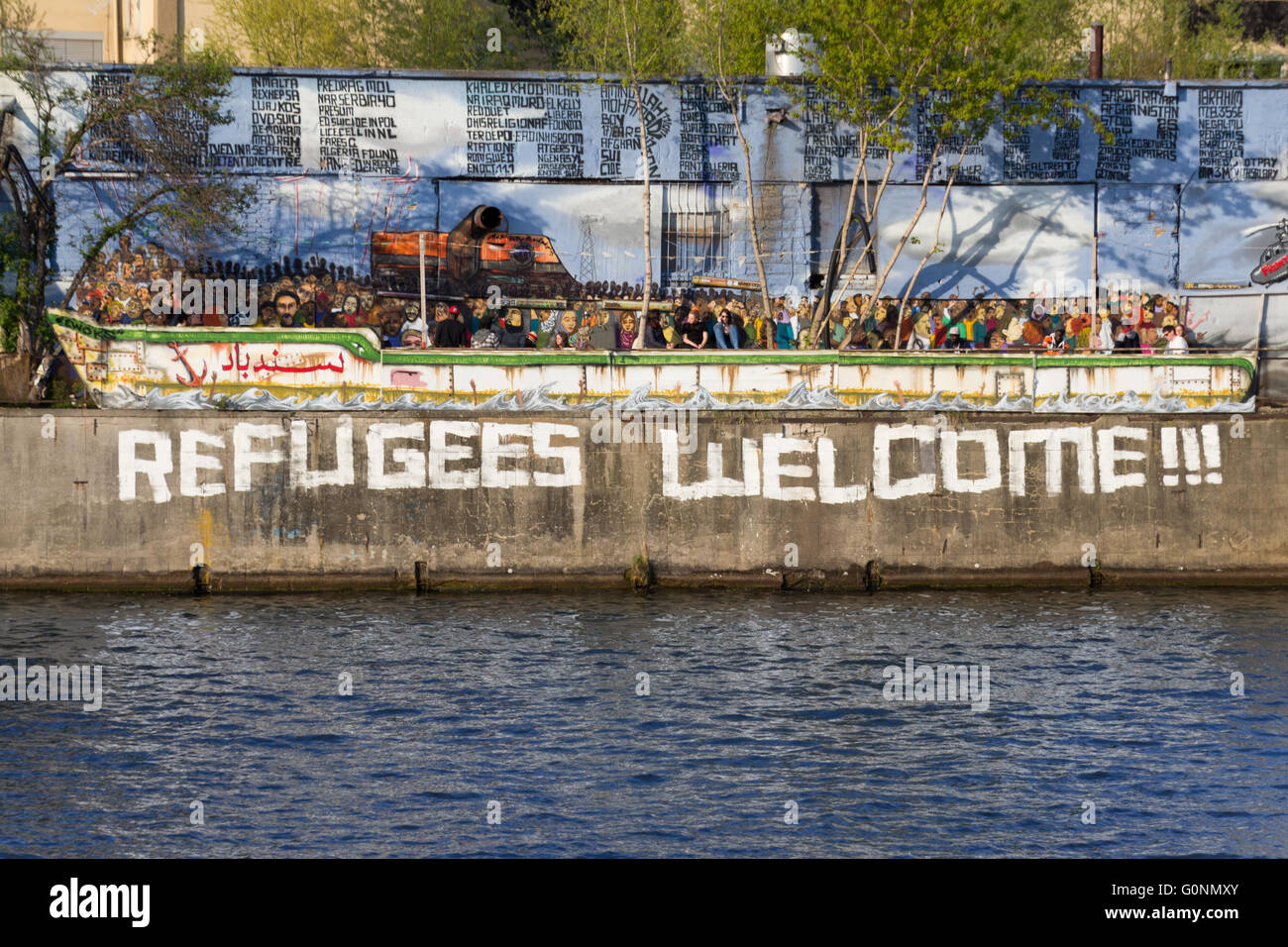Berlin, Deutsch - 30. April 2016: Flüchtlinge aufzunehmen, Graffiti und Flüchtling Boot Malerei in Berlin, Deutschland. Stockfoto