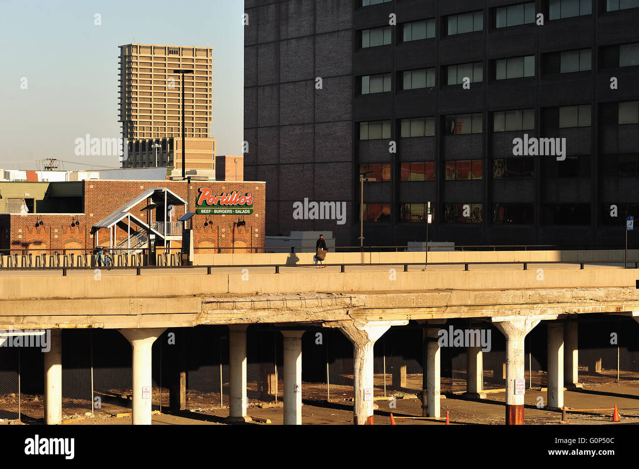 Chicago, Illinois, USA. Ein einsamer Mann macht sich auf den Weg entlang einer einsamen Straße in Chicago durch konkrete und Spalten eindeutig in der Notwendigkeit der Reparatur unterstützt. Stockfoto