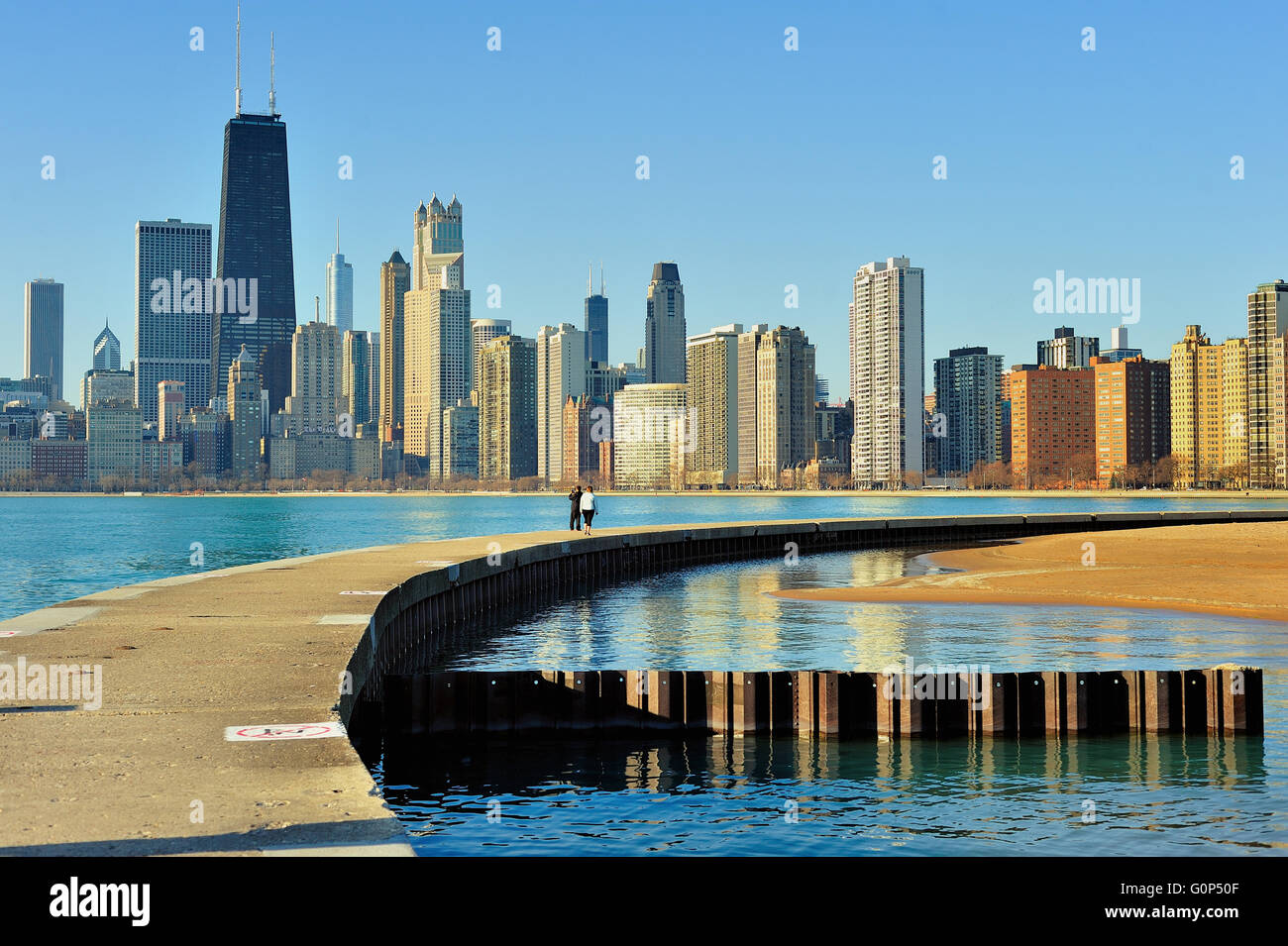 Ein paar Spaziergänge entlang eines Wellenbrechers, trennt den Lake Michigan aus einem kleinen Pool auf Chicagos North Avenue Beach. Chicago, Illinois, USA. Stockfoto