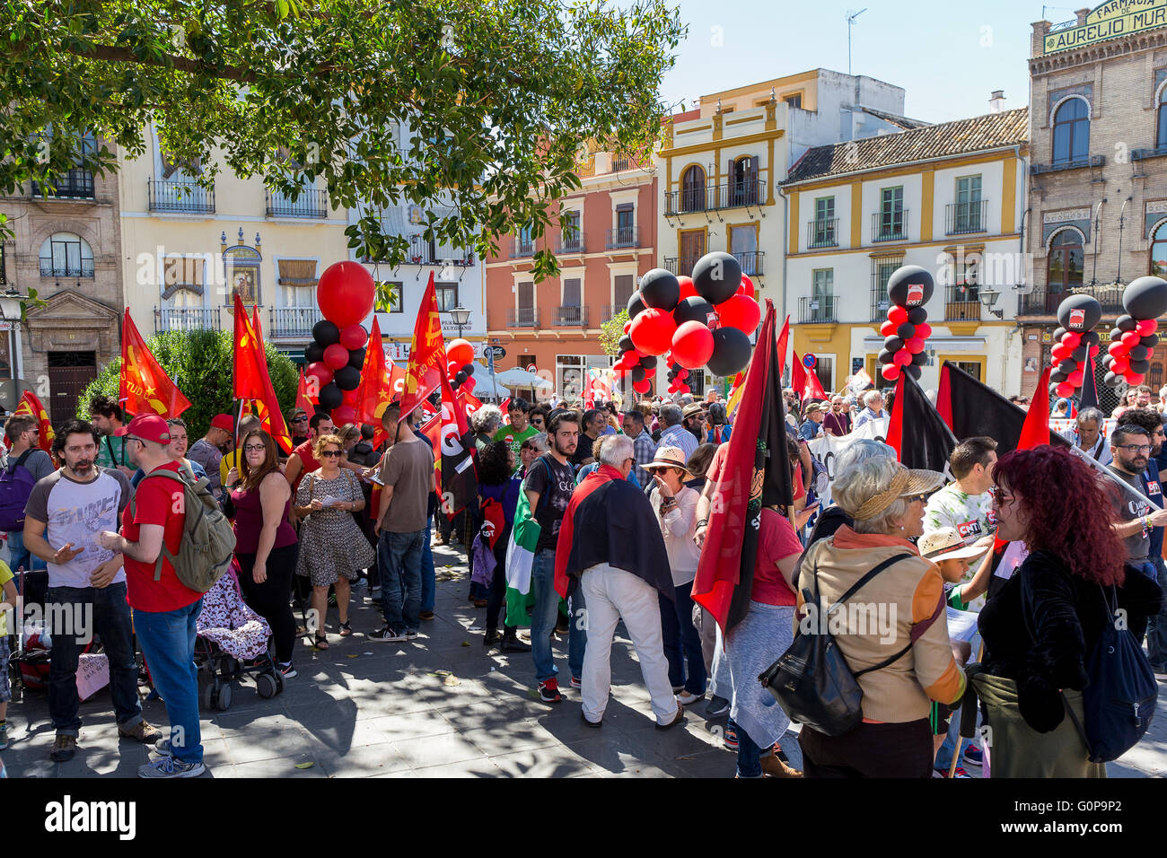 Arbeiter sammeln mit schwarzen und roten Luftballons und Fahnen, vor marschieren über die Triana-Brücke in Mayday-Rallye. Stockfoto