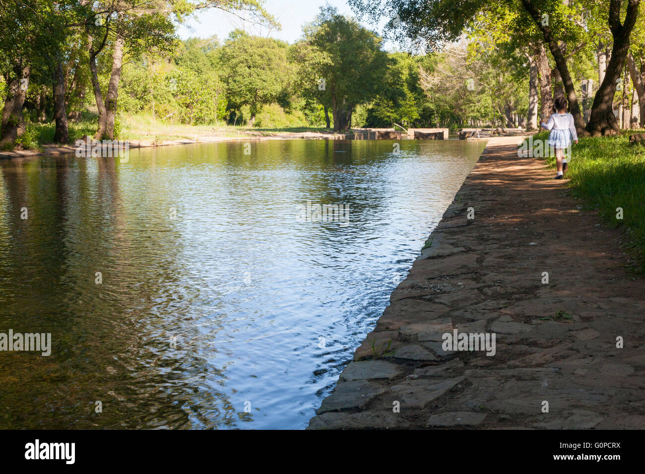 Kleinkind Mädchen spazieren ganz allein an La Codosera natürlichen Pools, Badajoz, Spanien Stockfoto