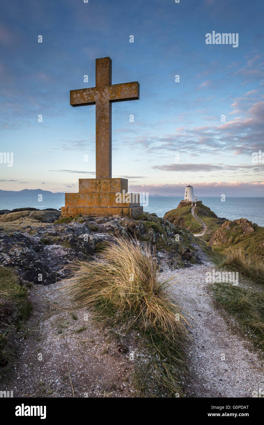 St Dwynwen Kreuz und Leuchtturm auf Llanddwyn Island, Anglesey, North Wales UK bei Sonnenaufgang Stockfoto