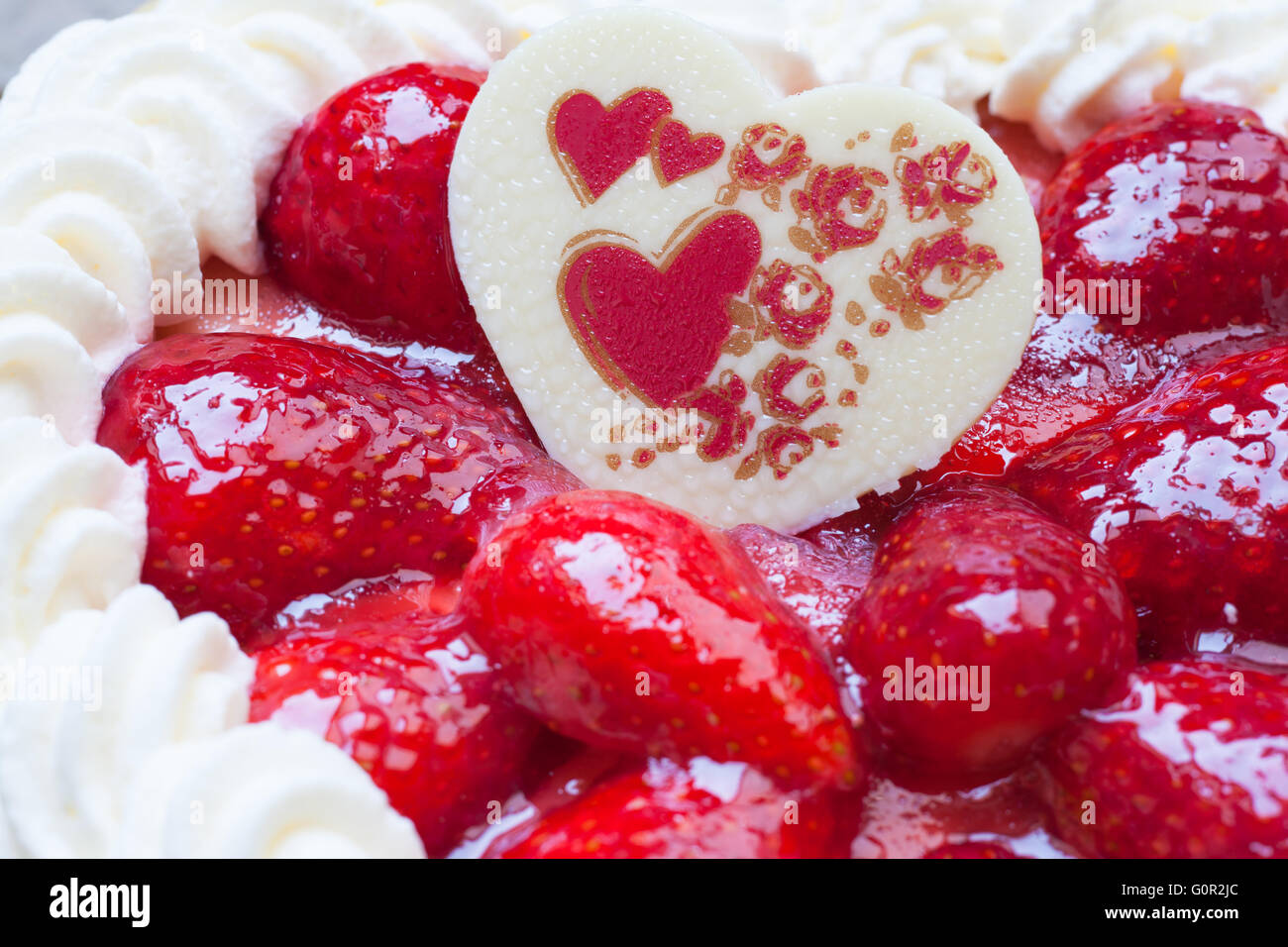 Nahaufnahme des Kuchens mit Erdbeer Herz Form Schokolade Geschenk zum Valentinstag Stockfoto