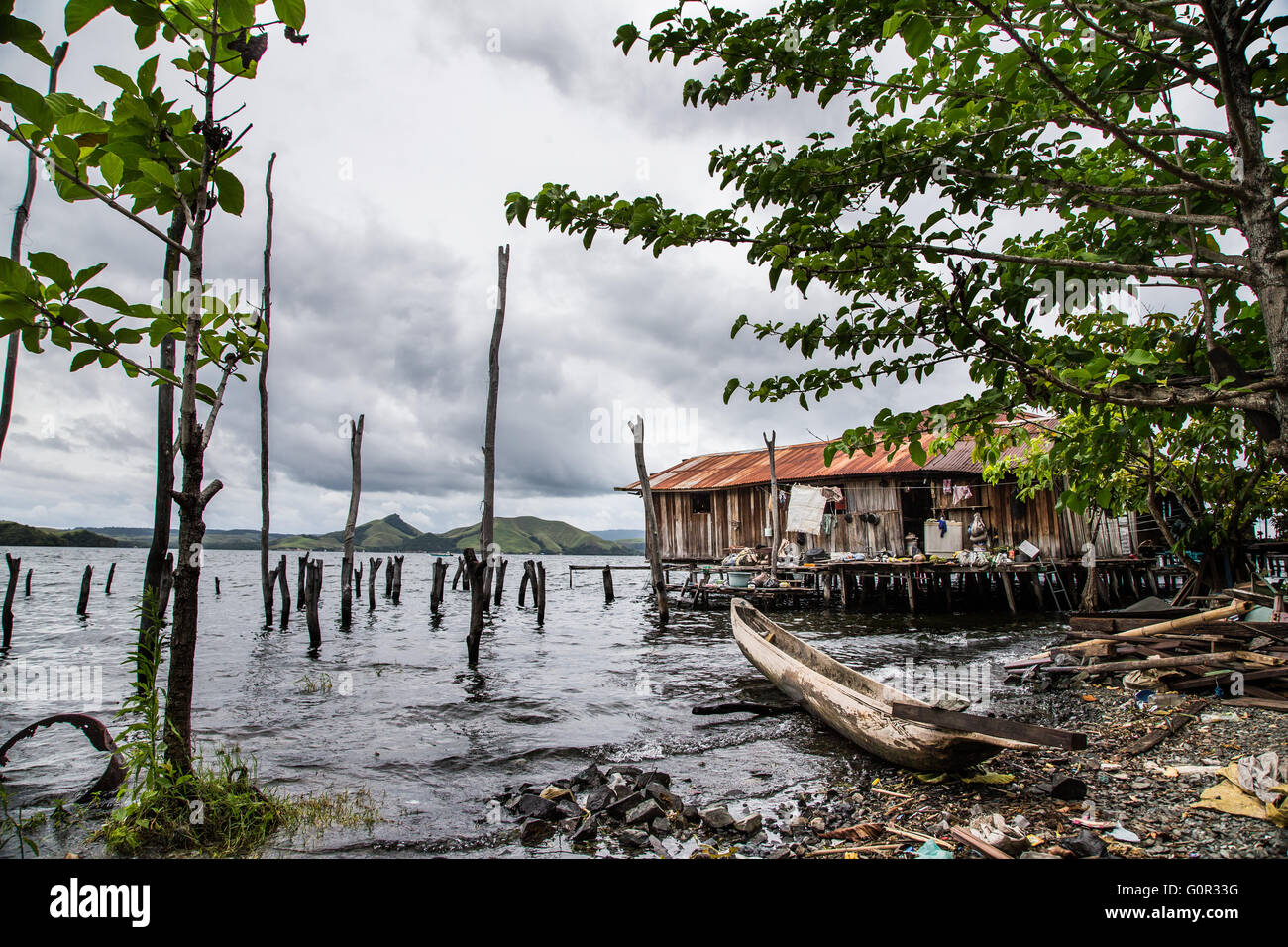 Haus am Meer und ein Boot in der Nähe geparkt, in Jayapura, West-Papua, Indonesien Stockfoto