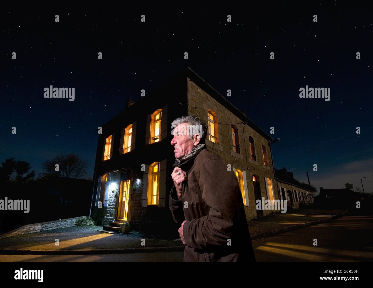 Mürrischer alter Mann in einer Straße in einer kalten Winternacht Stockfoto