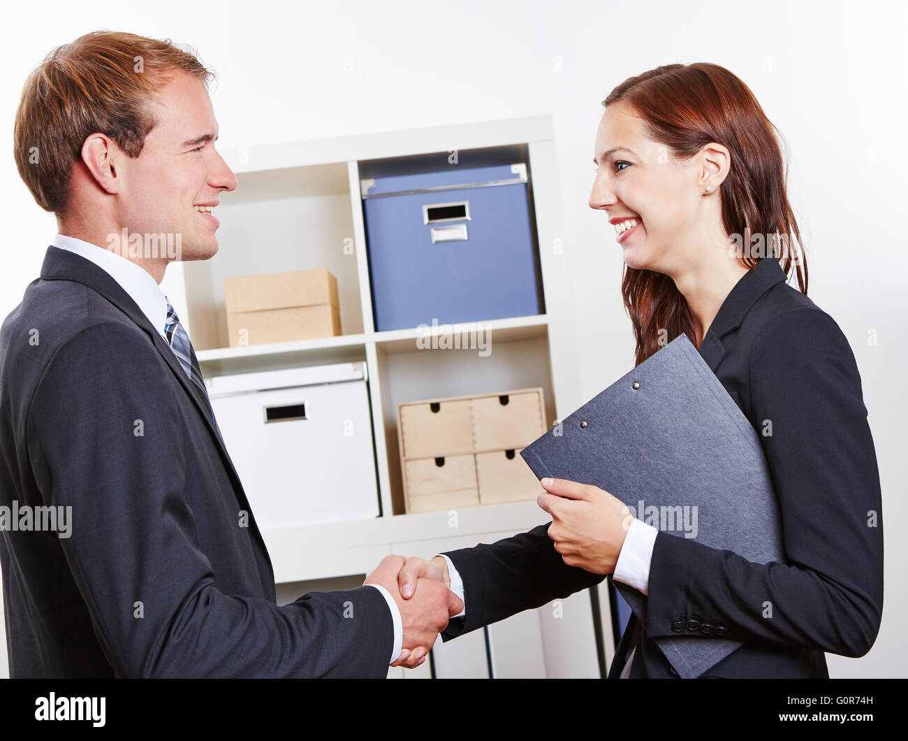 Zwei glückliche Geschäftsleute ihre Händeschütteln im Büro Stockfoto