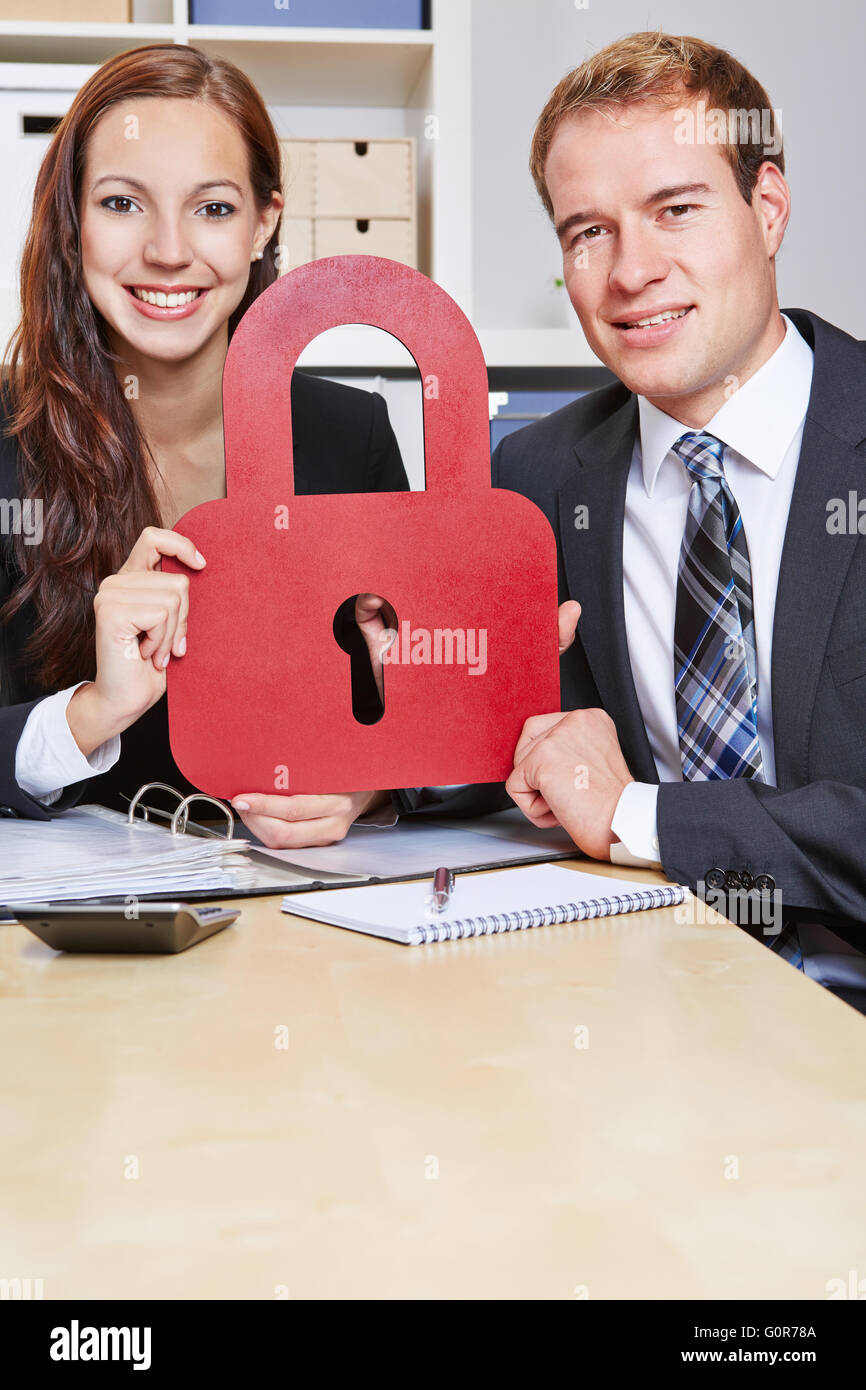 Zwei glückliche Geschäftsleute, die eine Sperre als Sicherheitssymbol Stockfoto