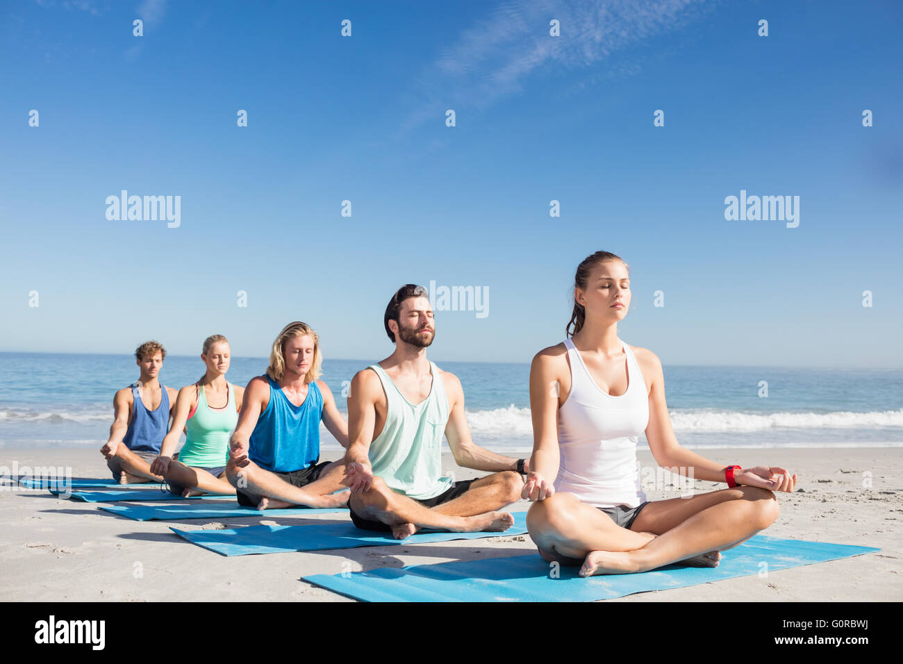 Menschen, die Yoga am Strand Stockfoto