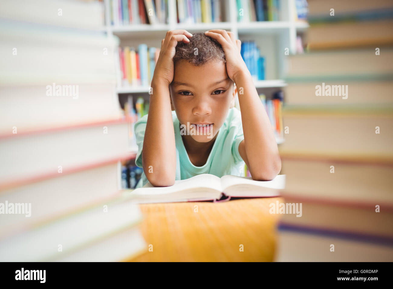 Junge sitzt an einem Schreibtisch Stockfoto