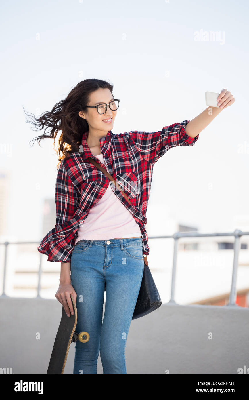 Hipster mit Skateboard fotografieren Stockfoto