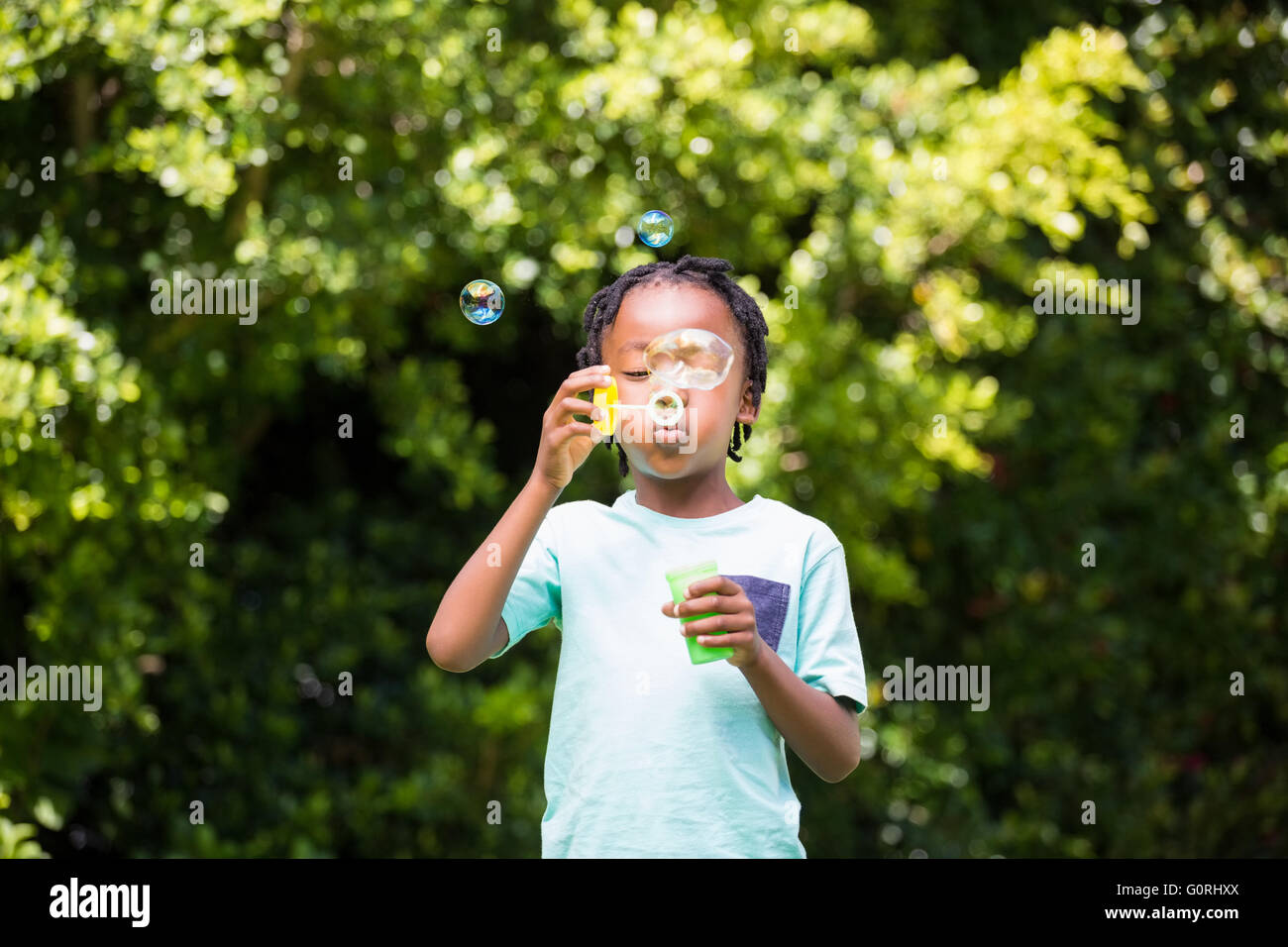 Eine kleine Junge blowing bubbles Stockfoto
