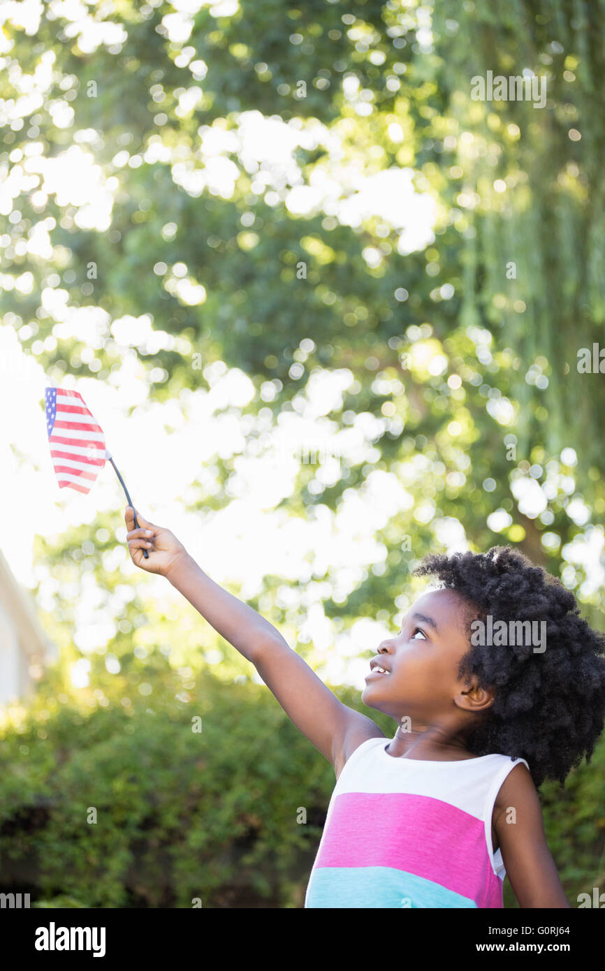 Ein kleines Mädchen ist eine amerikanische Flagge in der Luft halten. Stockfoto