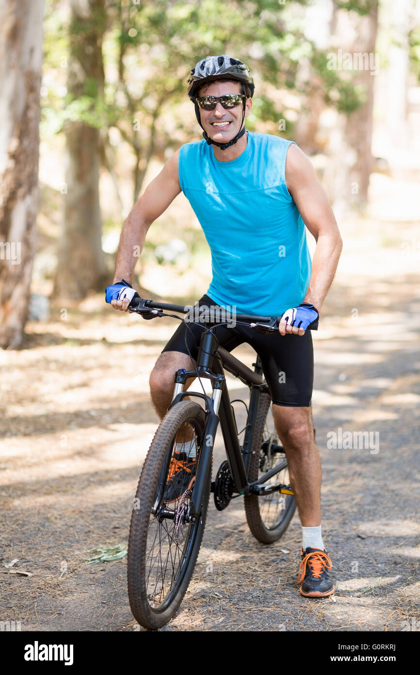 Mann lächelnd und posiert mit seinem Fahrrad Stockfoto