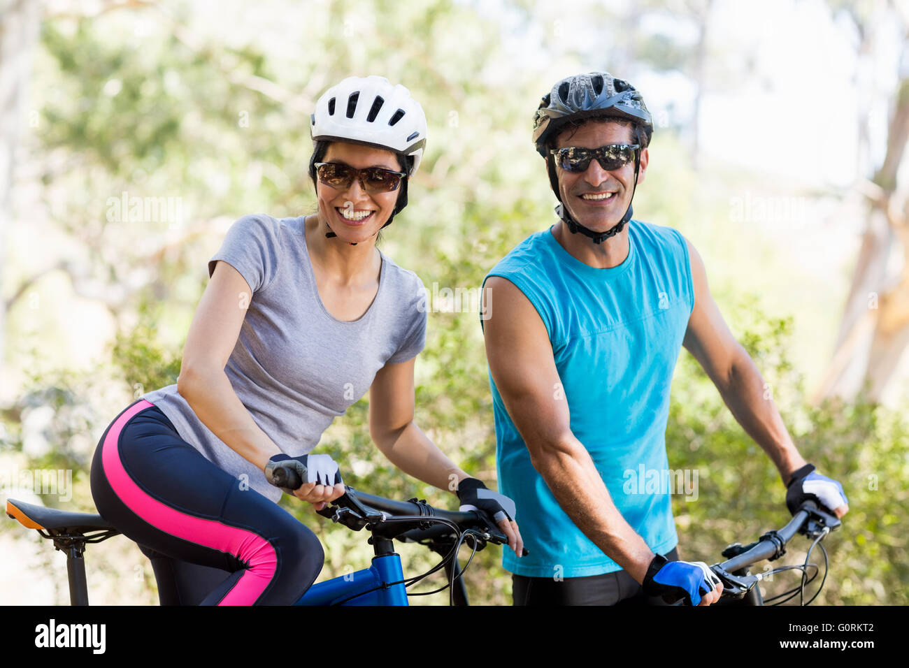 Paar Lächeln und posieren mit ihren bikes Stockfoto